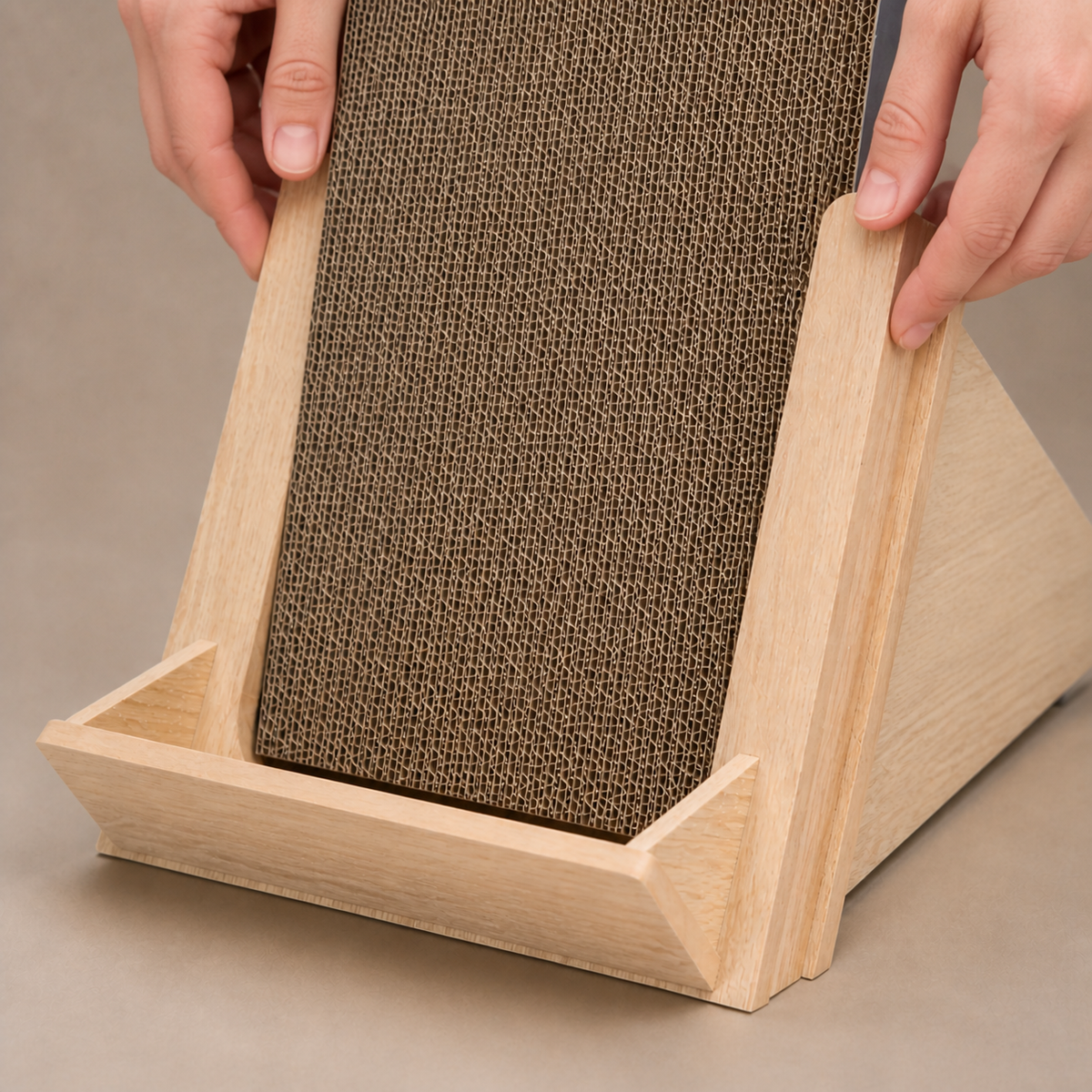 Hands seating a fresh corrugated insert in the Basic Incline Cat Scratcher frame